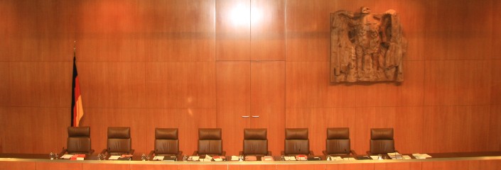 Die Stühle der Verfassungsrichter im Sitzungssaal des Bundesverfassungsgericht. An der Wand ist die bekannte Schnitzerei des Bundesadlers zu sehen.