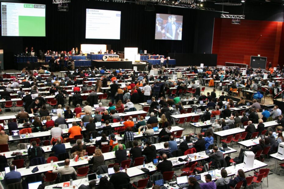 Symbolbild: Halle mit parlamentarischer Bestuhlung und vielen Menschen